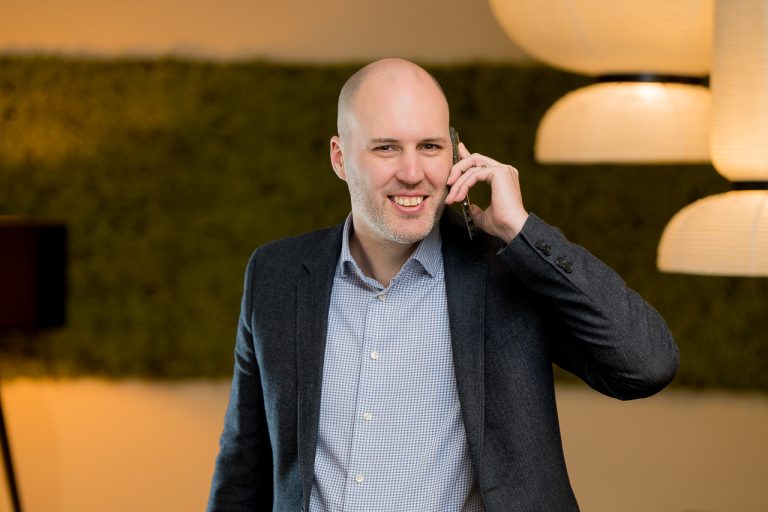 Portretfoto van onze directeur, Alexander Begheyn aan de telefoon